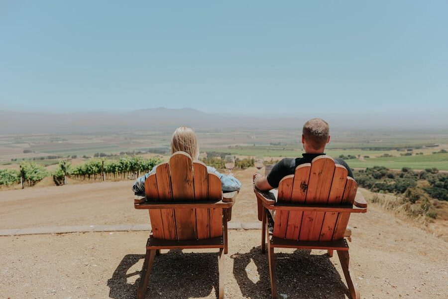 A couple in chairs overlooking a vineyard