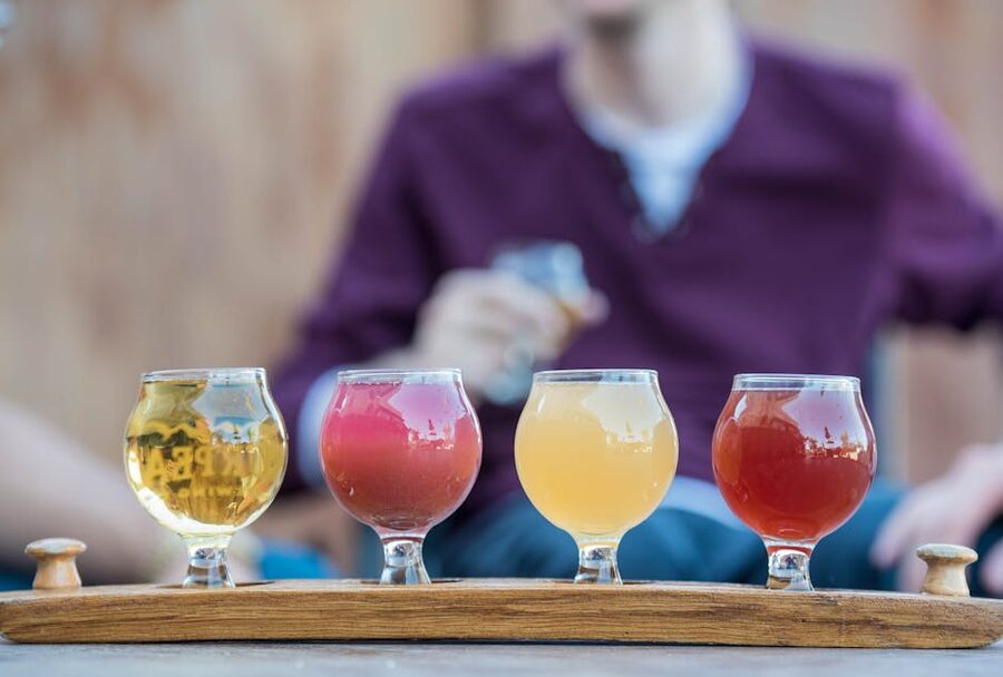 A four-glass tasting flight on a wooden tray