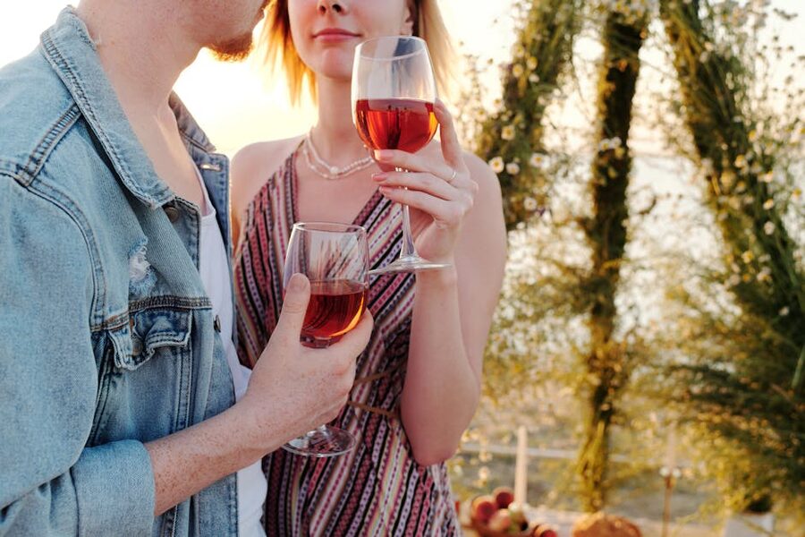 Couple toasting wine glasses at sunset
