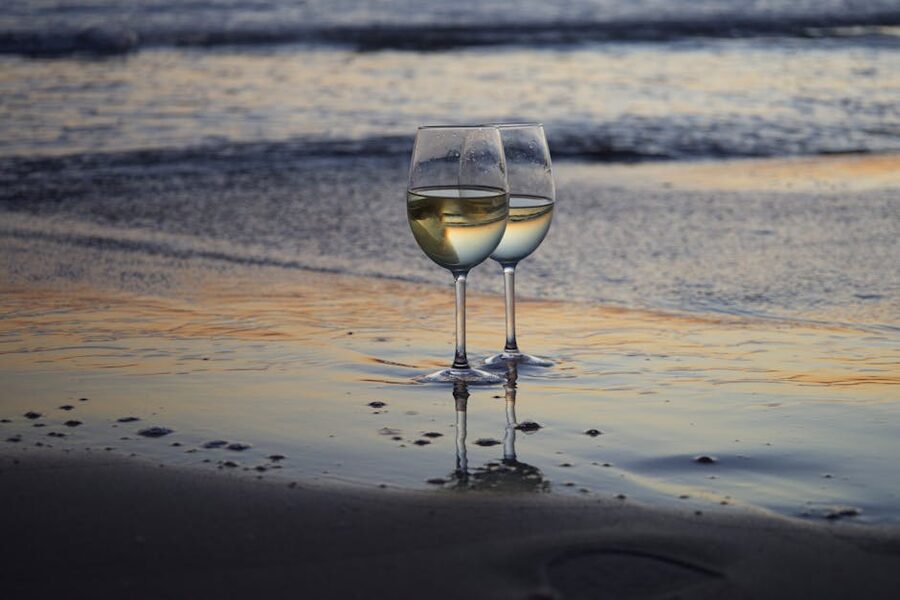 Two wine glasses on a table at sunset