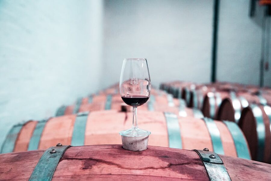 Wine glass on oak barrel in winery cellar