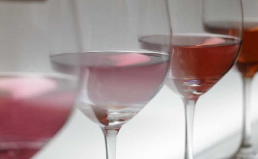 Multiple rose wine glasses in soft lighting