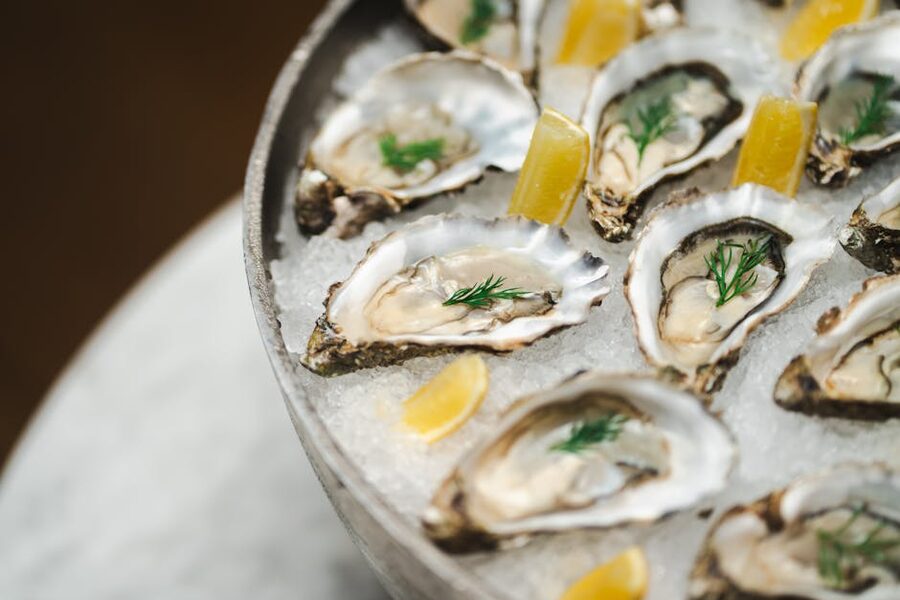 A platter of fresh oysters on ice with lemon