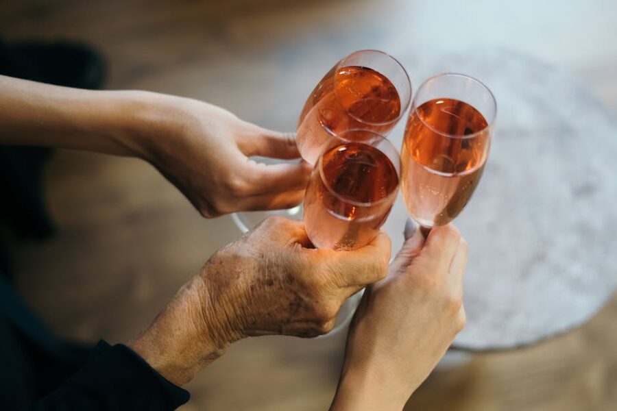 Three rose sparkling wine glasses being clinked in a celebratory toast